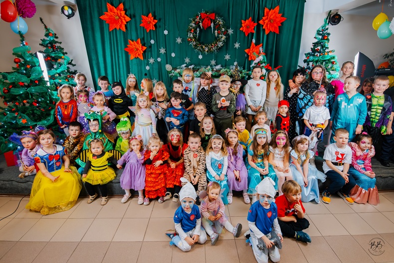 Uczestnicy balu na zdjęciu grupowym - dzieci z pomalowanymi twarzami.